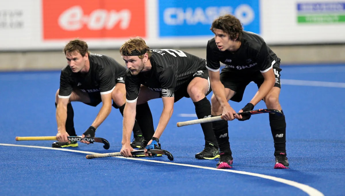 Three defenders prepare to run out at a hockey penalty corner