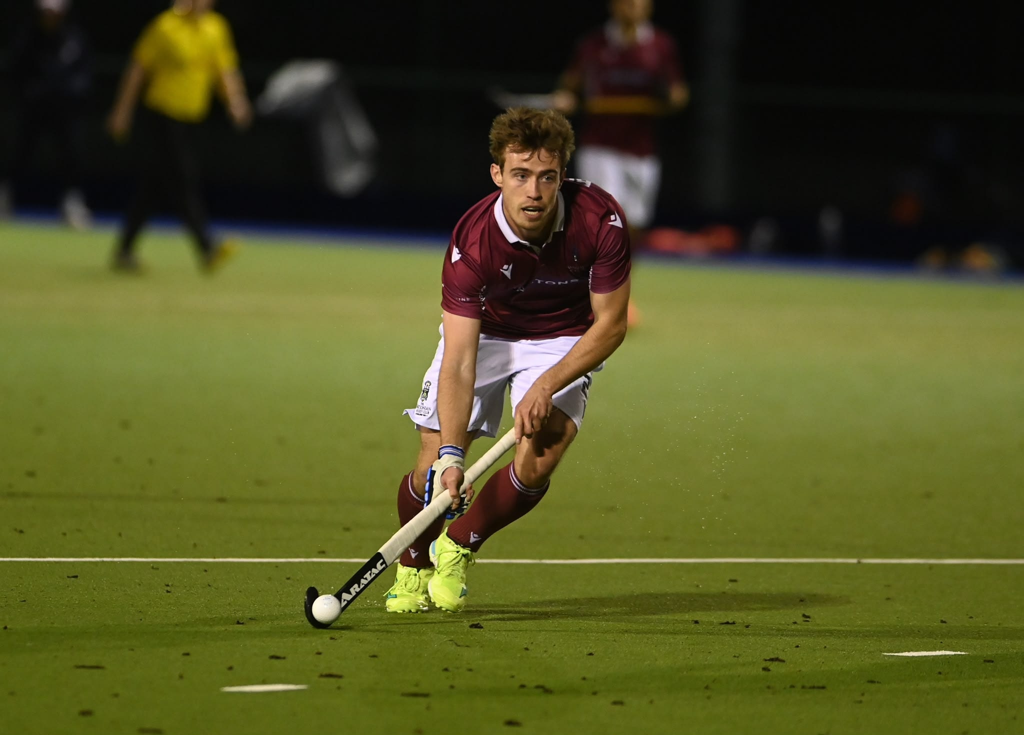 Aratac hockey player carrying the ball during a night match