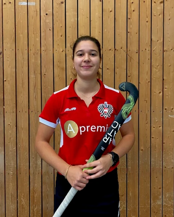 Carla Kemper holding her Aratac hockey stick indoors.