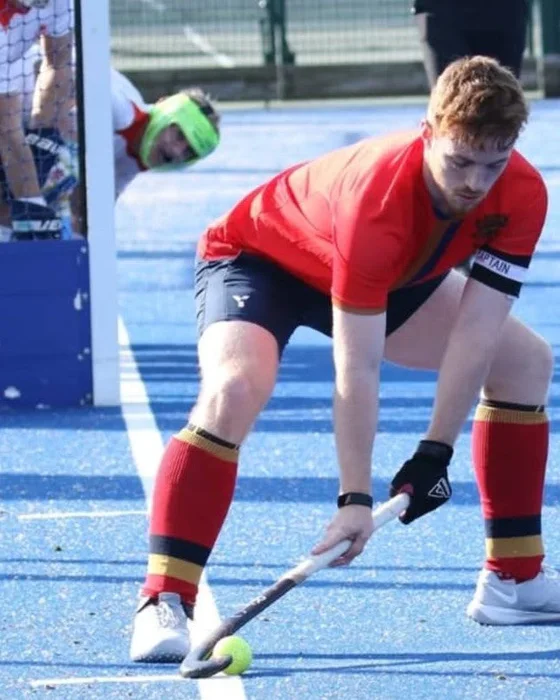 Duncan Gladwin receiving the ball during a hockey match.