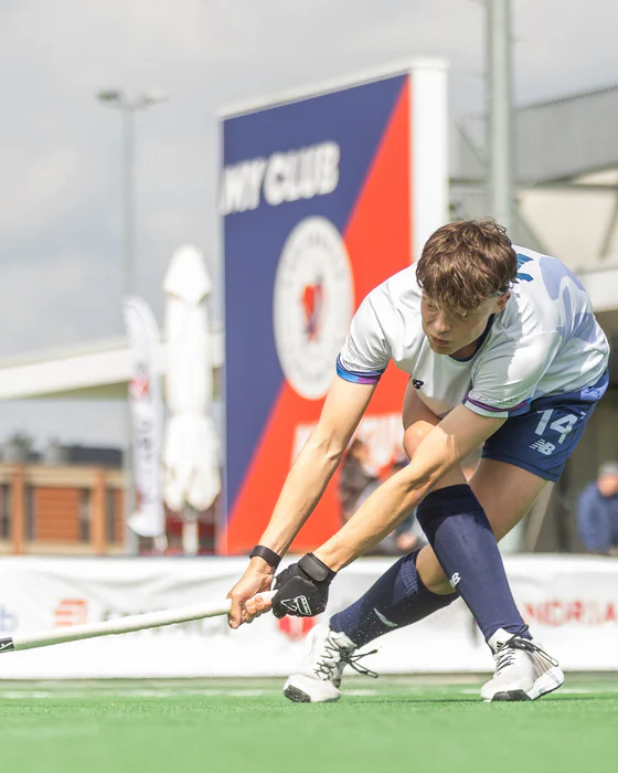 Matthew Leiper playing the ball during a competitive hockey match.